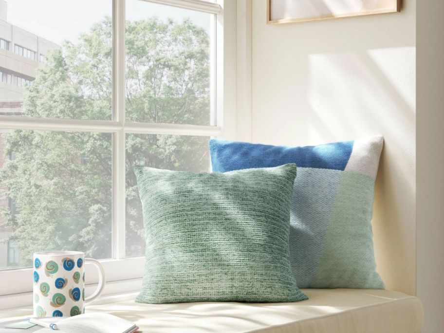 two square throw pillows on a window seat