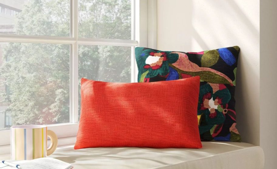 two square throw pillows on a window seat