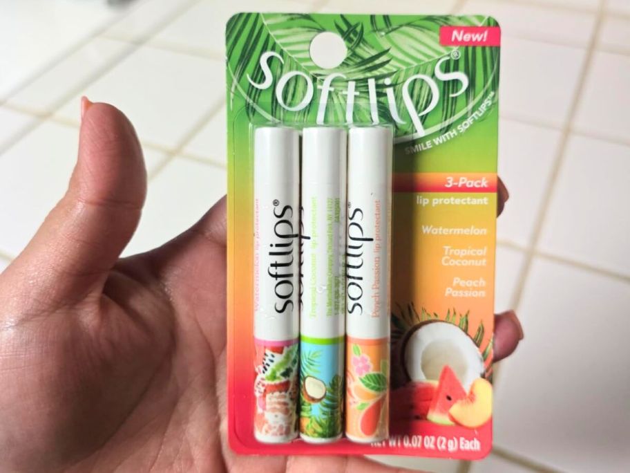A person holding a 3-Pack of Softlips chapstick