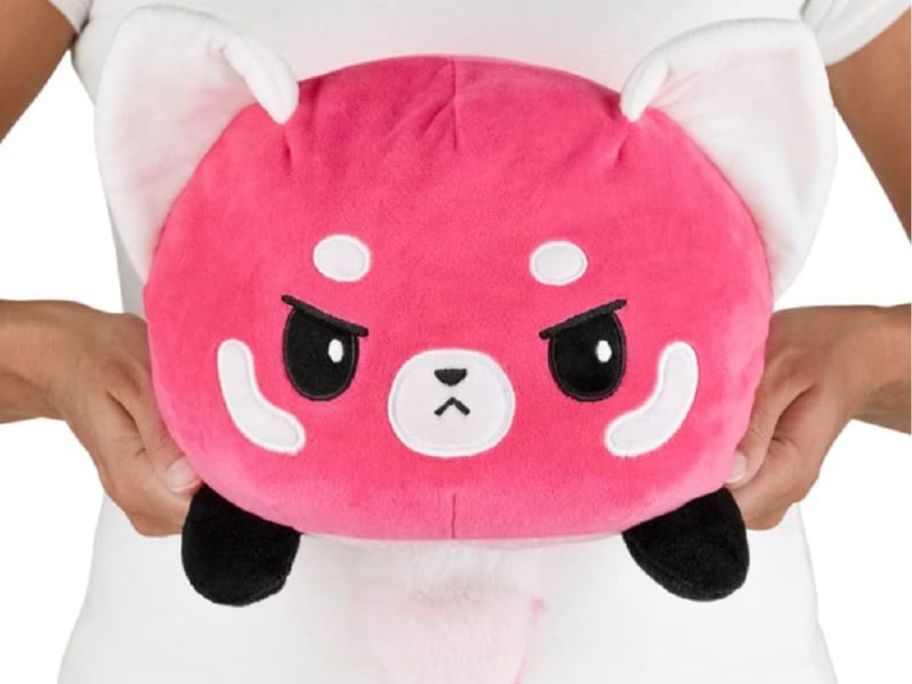 A person holding a TeeTurtle Original Reversible Big Red Panda Plush
