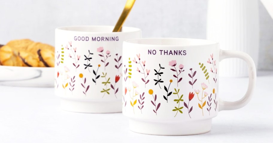 two floral print coffee mugs that say "good morning" and "no thanks"