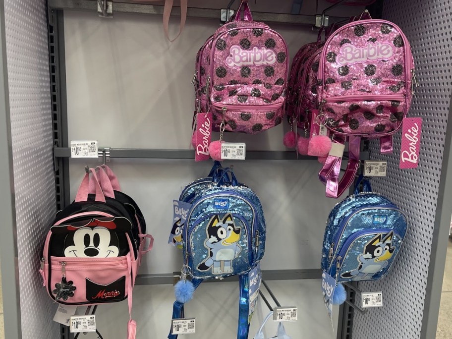 mini character backpacks hanging on display in store