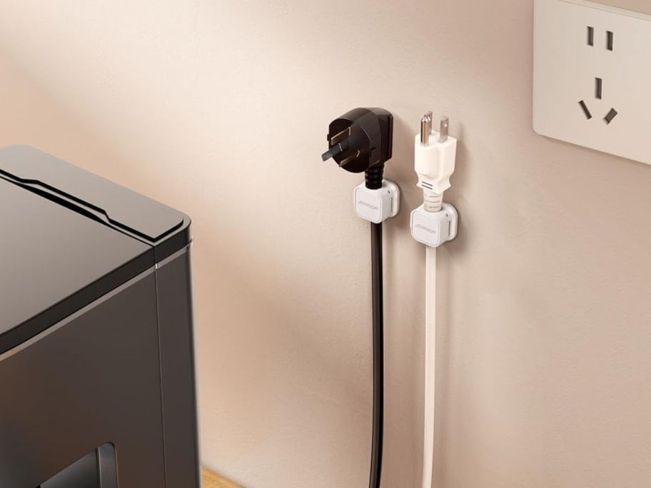2 cord holders on wall with cords in them