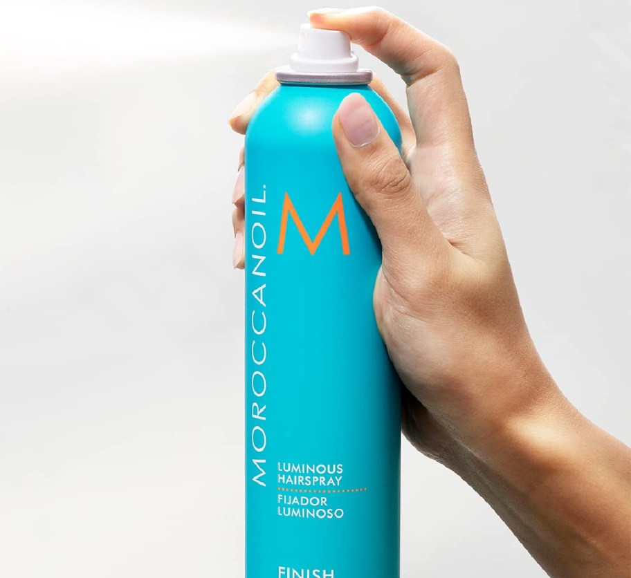 hand spraying blue hairspray can