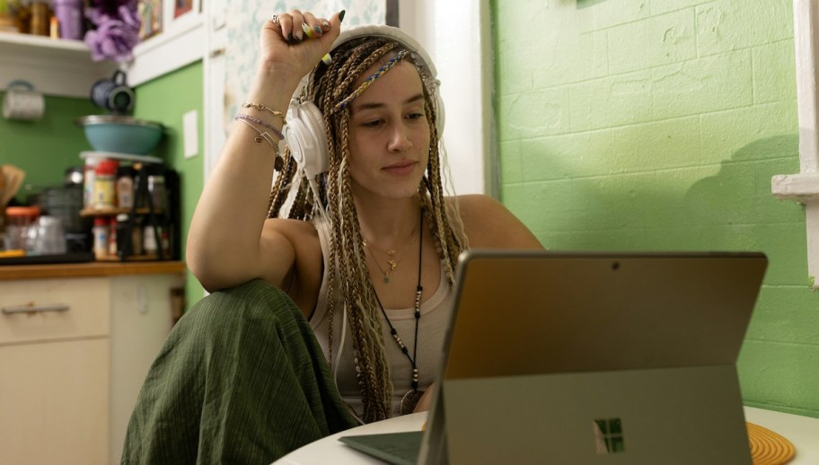student sitting at laptop in kitchen