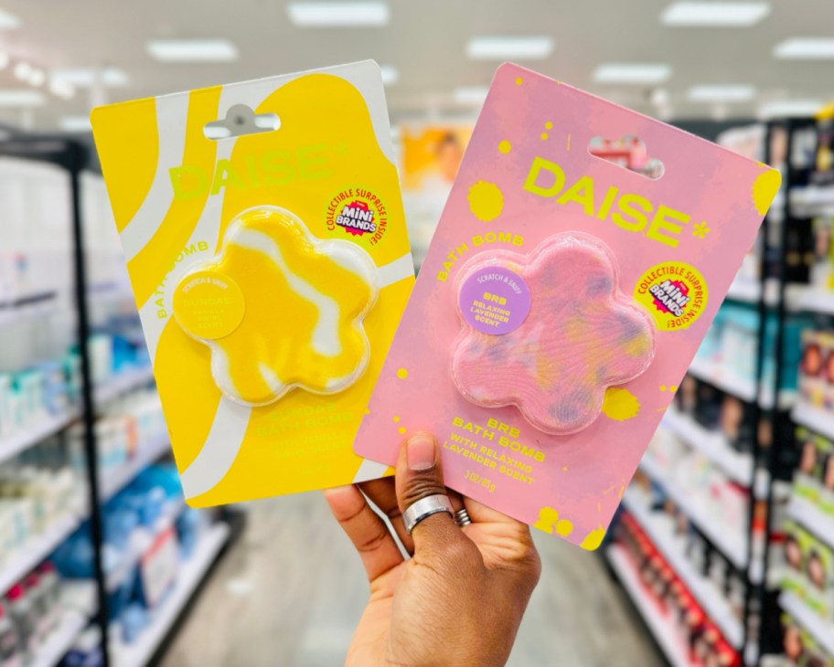 pink and yellow flower-shaped bath bombs in hand