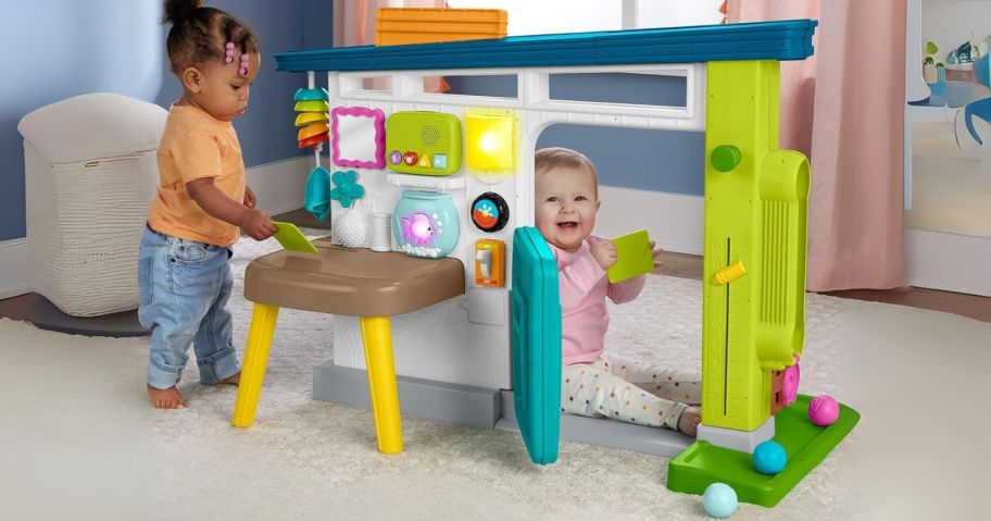 kids playing in and around Fisher-Price Laugh & Learn Ultimate Playhouse i living room