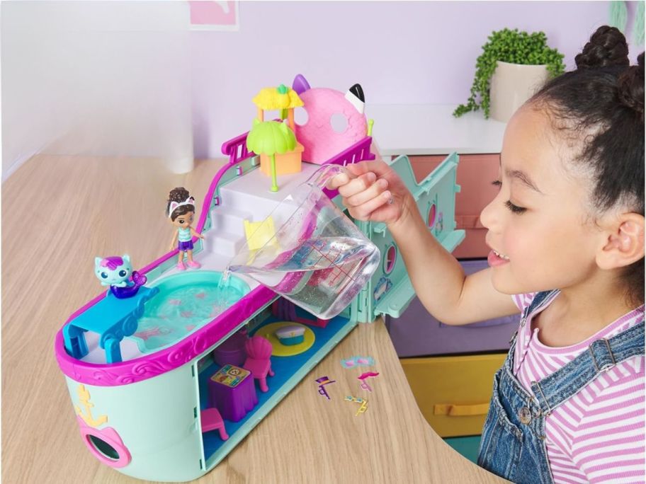 girl playing Gabby's Dollhouse Gabby Cat Friend Ship on table
