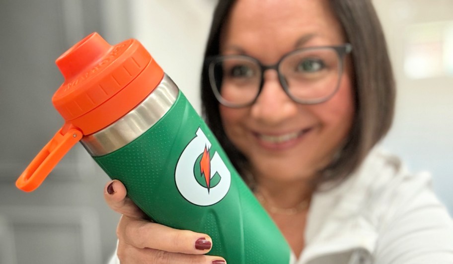 woman smiling behind a green gatorade bottle