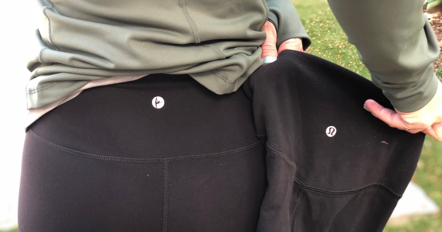 hands holding up identical pair of black leggings