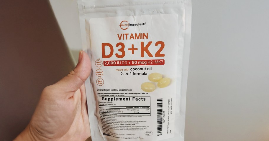 hand holding a bag of vitamin d3 and k2 supplements