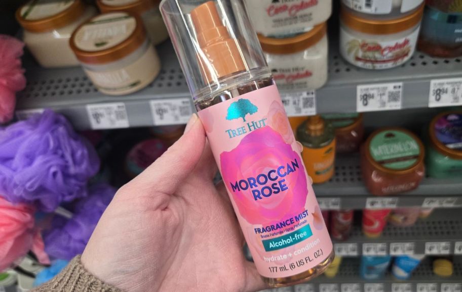 a womans hand holding a bottle of moroccan rose fragrance mist