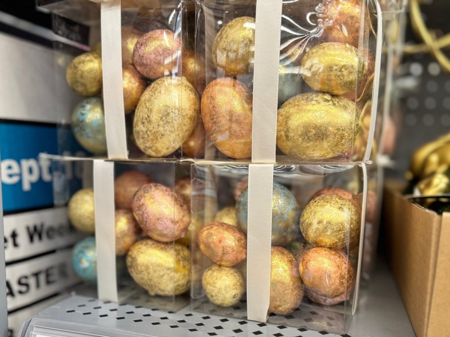 gold, rose gold, bluish gold and greenish gold foil faux Easter eggs in plastic boxes on a store shelf