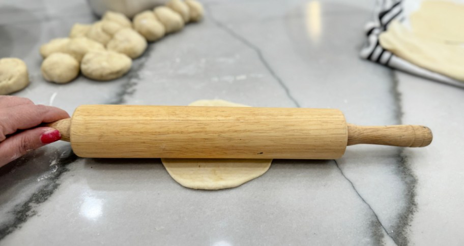 rolling out tortillas on the counter (