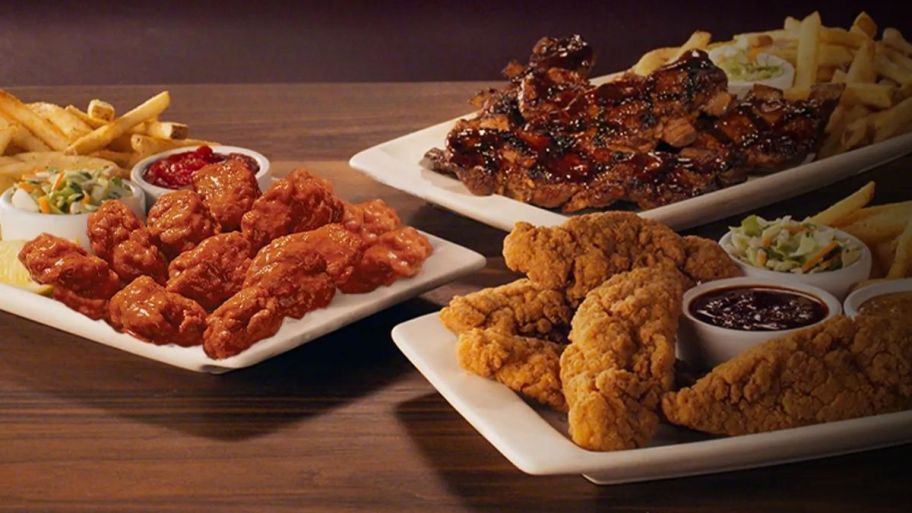 plates of applebees boneless wings, tenders, riblets served with fries and coleslaw