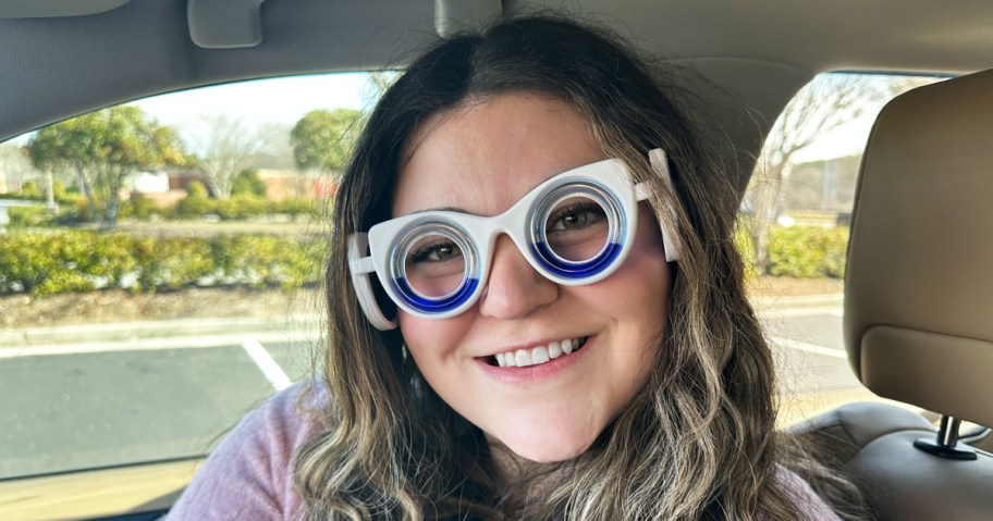 young woman wearing motion sickness glasses in a car