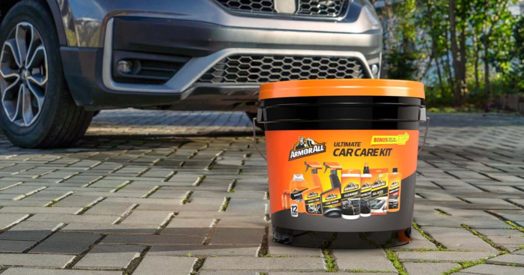 Armor all car care kit on cobblestone driveway in front of silver car