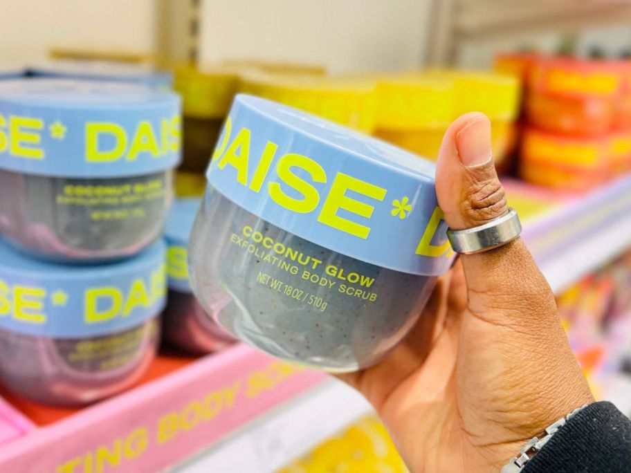 Hand holding a daise body scrub