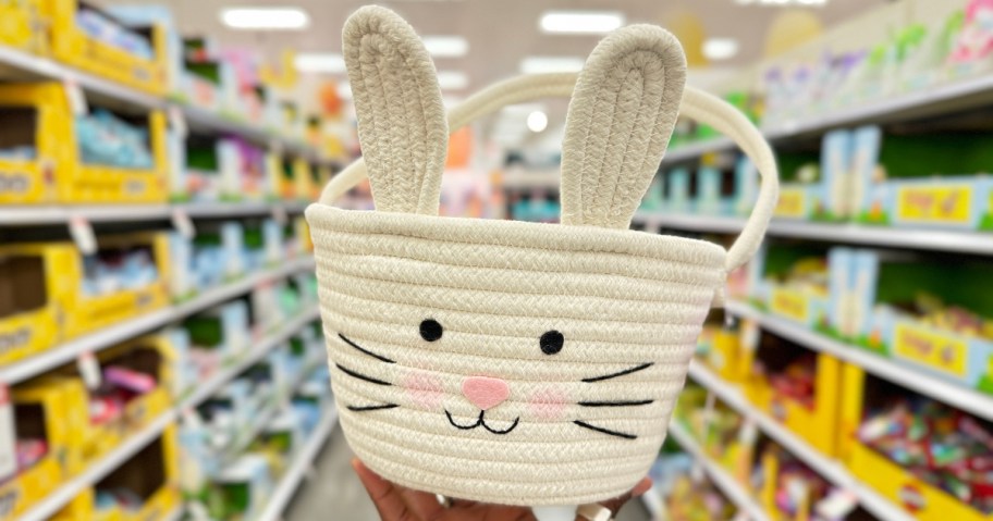 hand holding a bunny rabbit rope basket in a store aisle