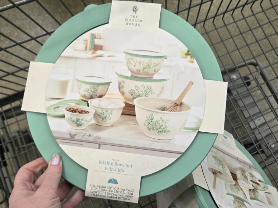 hand holding a set of nesting mixing bowls in green and white with flowers 