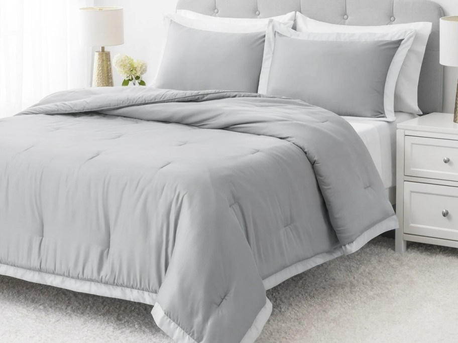 grey comforter and shams set on bed