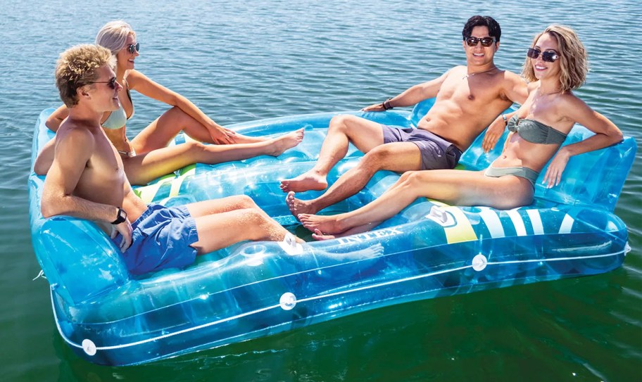 four people floating on blue inflatable raft