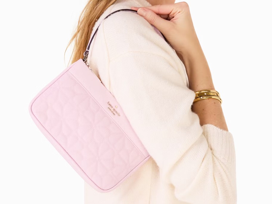 woman holding pink kate spade bag on shoulder