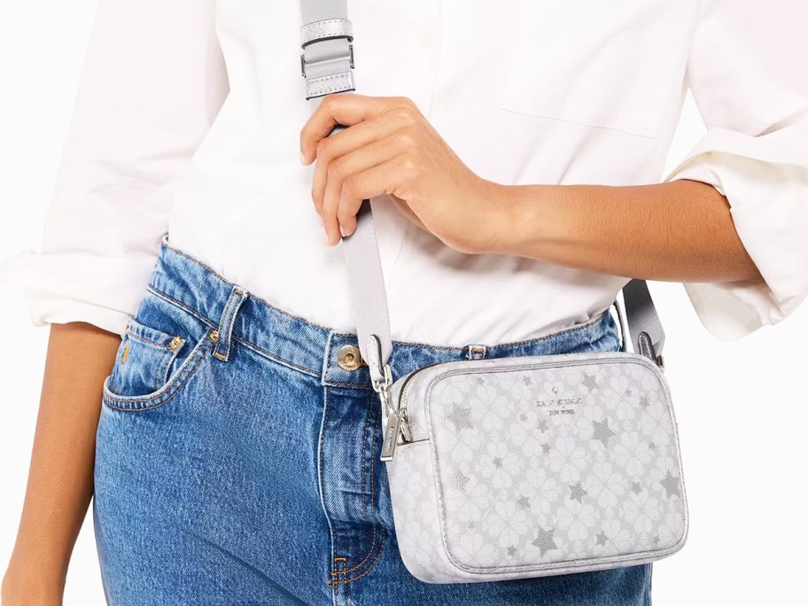woman in white top and jeans with grey star print crossbody bag