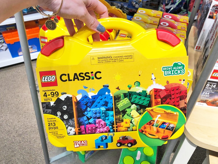 hand holding yellow LEGO Classic Creative Suitcase set in store