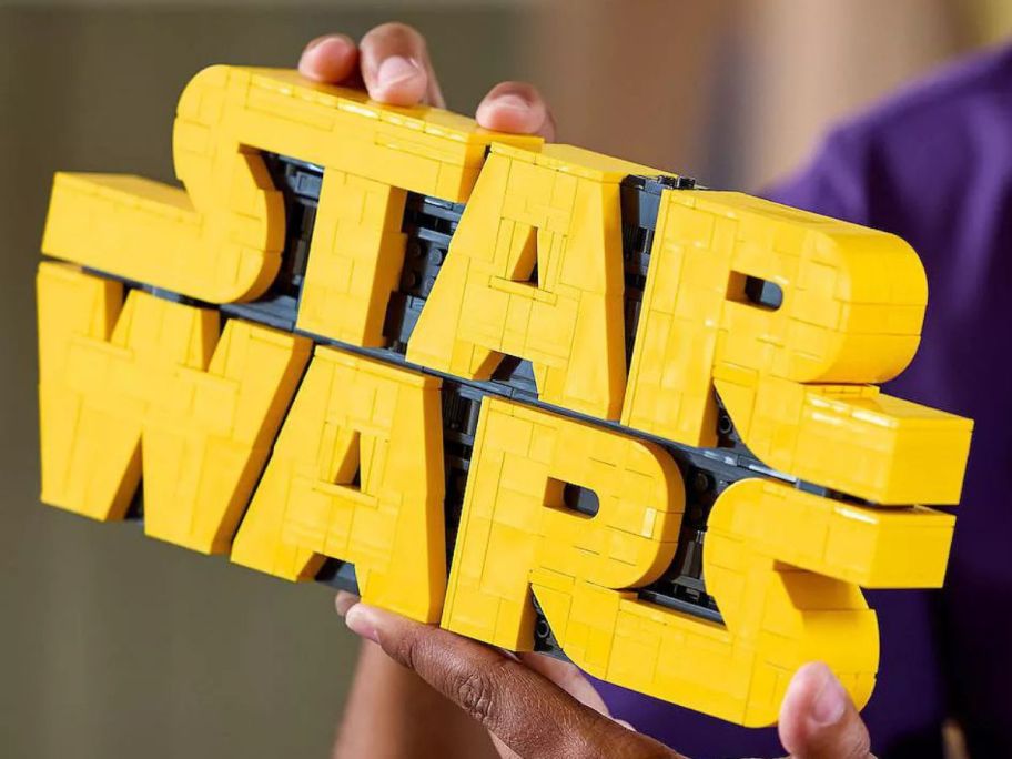 Hand holding the LEGO Star Wars Logo