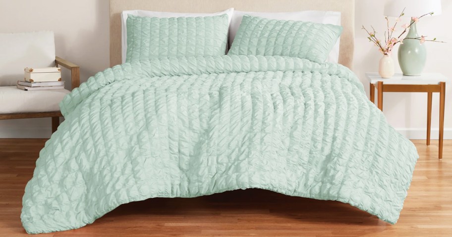 green comforter and shams set on bed