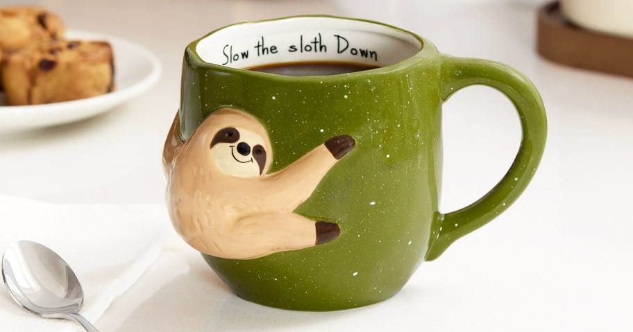 green sloth mug that says "slow the sloth down"