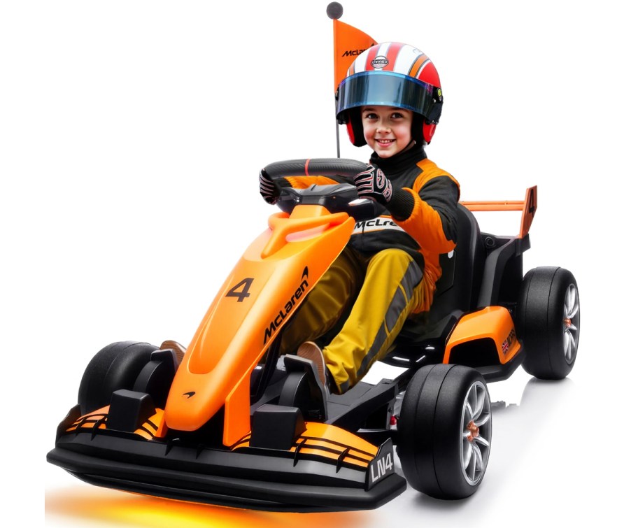 boy sitting on an orange and black McLaren-themed go kart