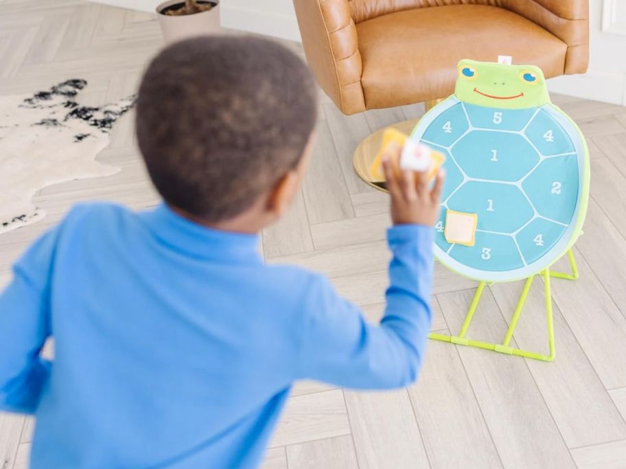 Child throwing a bean bag at a Melissa & Doug Dilly Dally Target Game
