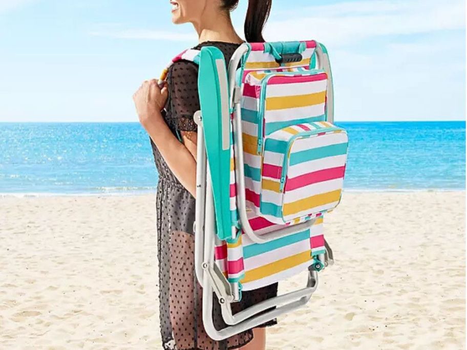 Woman carrying a folded Member's Mark Beach Chair on her back