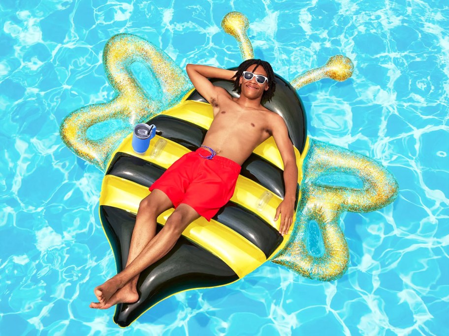 man laying on a bee pool inflatable