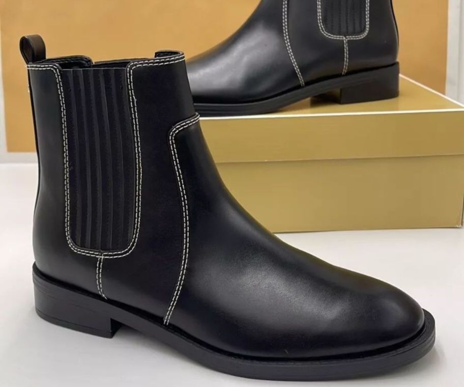 A Michael Kors Ella Chelsea Boot in Black on a box