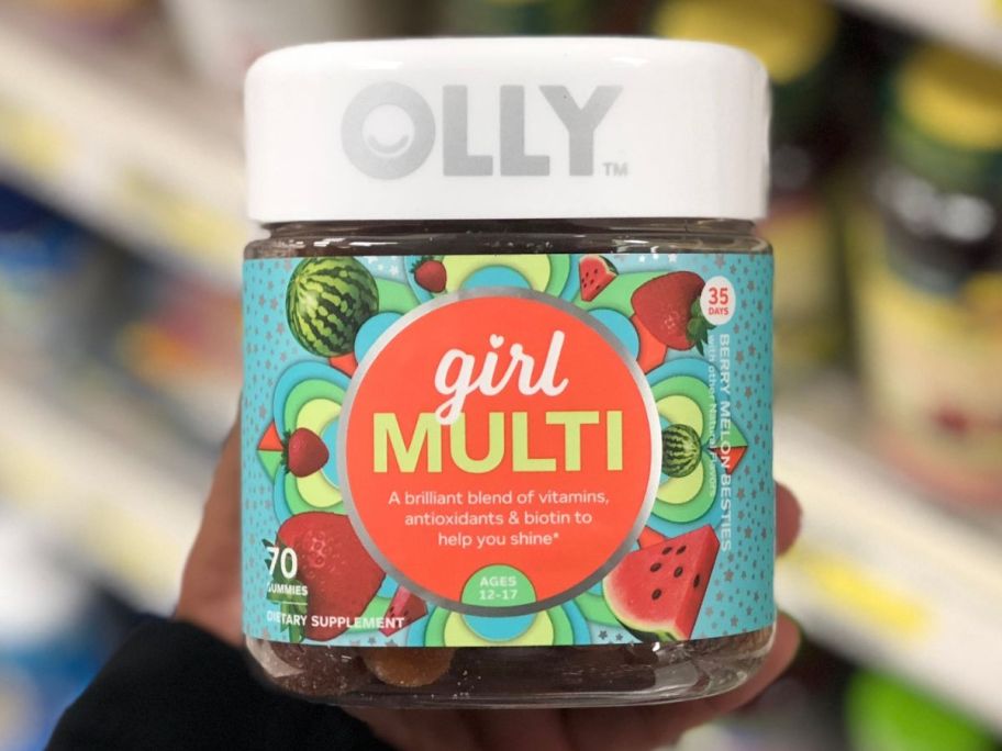 Hand holding a bottle of Olly Teen Girl Gummy Vitamins