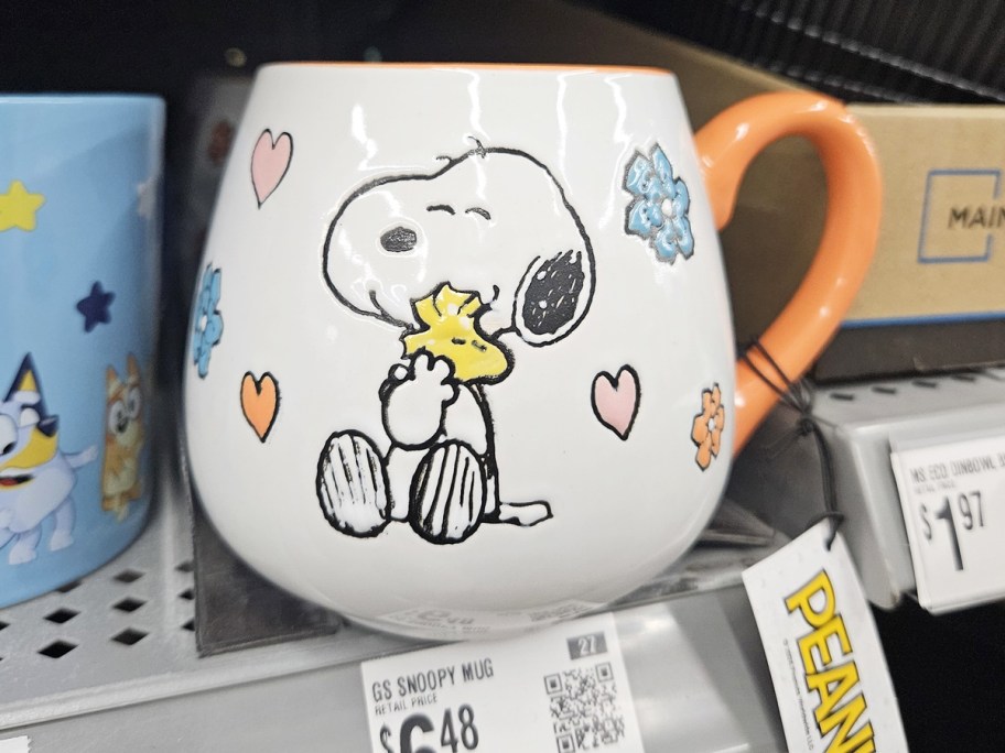 white and orange coffee mug of snoopy hugging woodstock