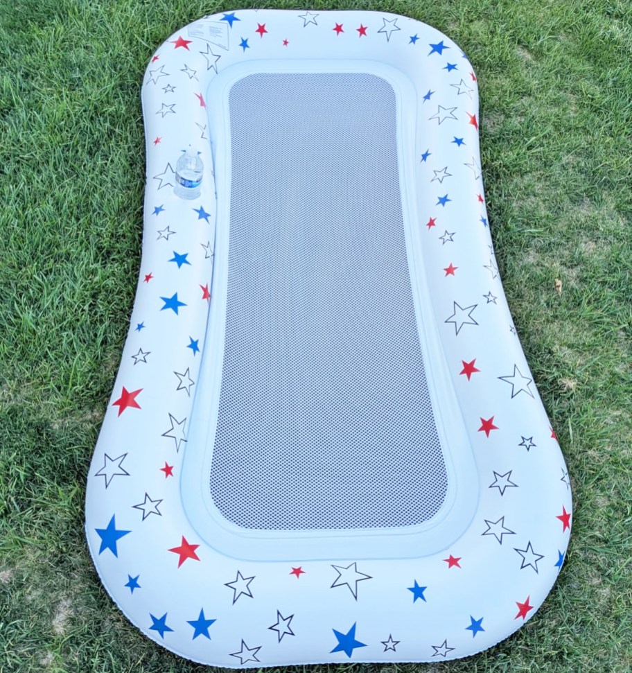white pool float with red and blue stars on grass