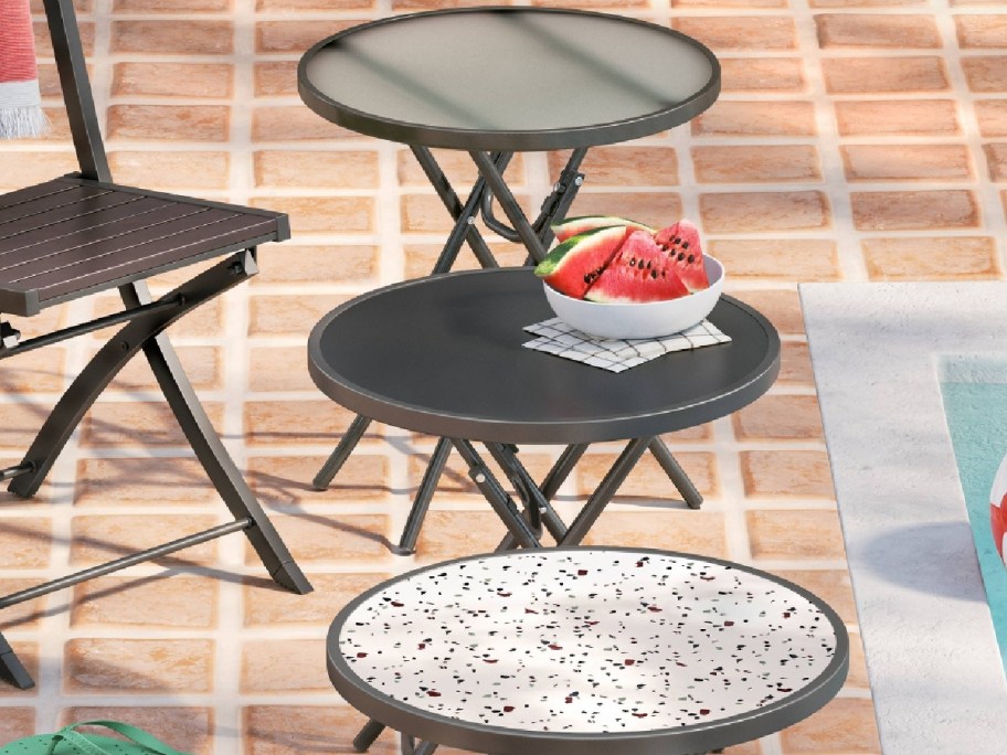 three different sitting patio tables displayed