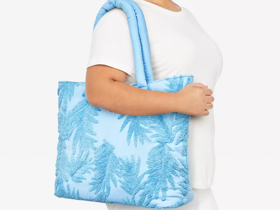 woman in white tee with a large blue tote bag