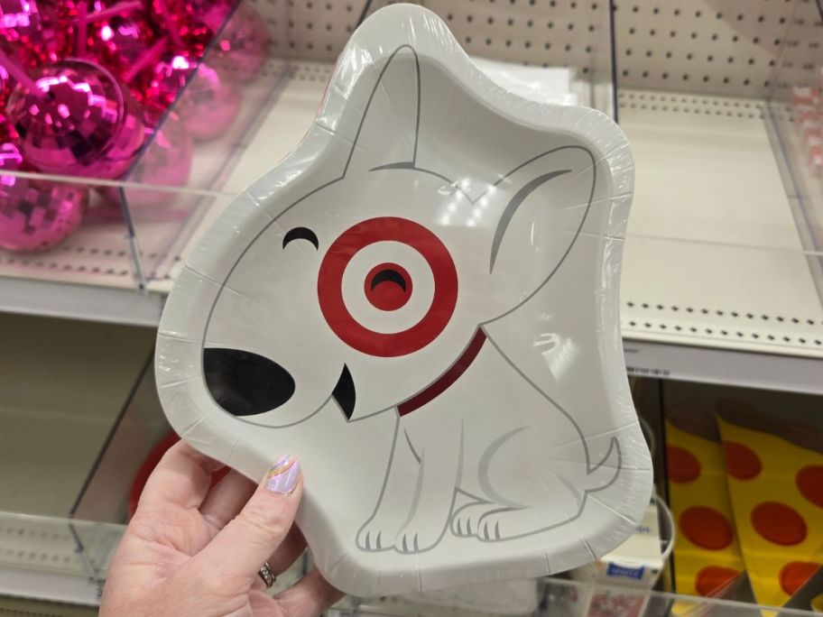Hand holding a Spritz Target Bullseye Dog Shaped Snack Plates 20-Count