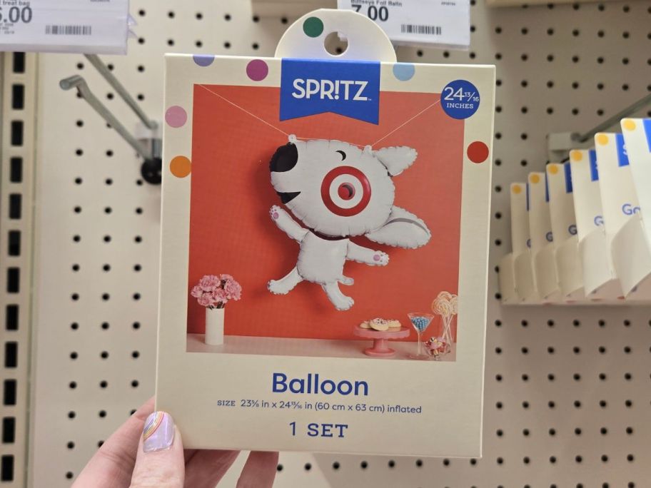 Hand holding a Spritz Target Bullseye Dog Shaped Foil Balloon