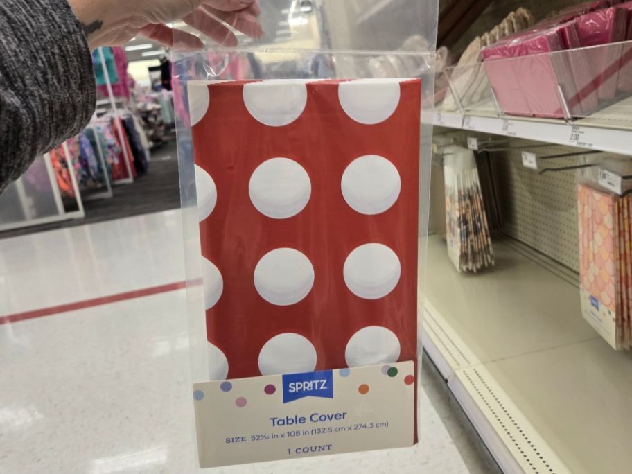 Hand holding a Spritz Target Red and White Dot Table Cover 