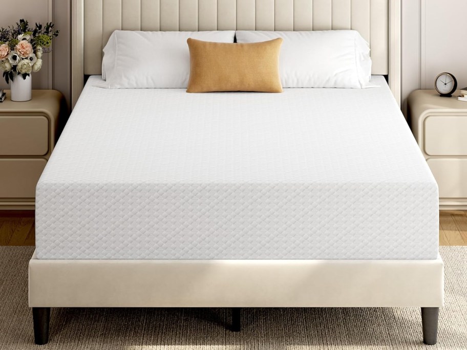 white memory foam mattress on an upholstered bed frame with pillows on top