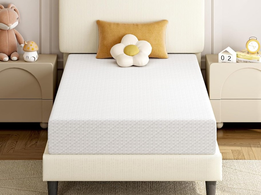 white memory foam mattress on an upholstered bed frame with pillows on top