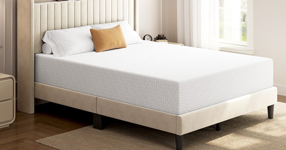 white memory foam mattress on an upholstered bed frame with pillows on top