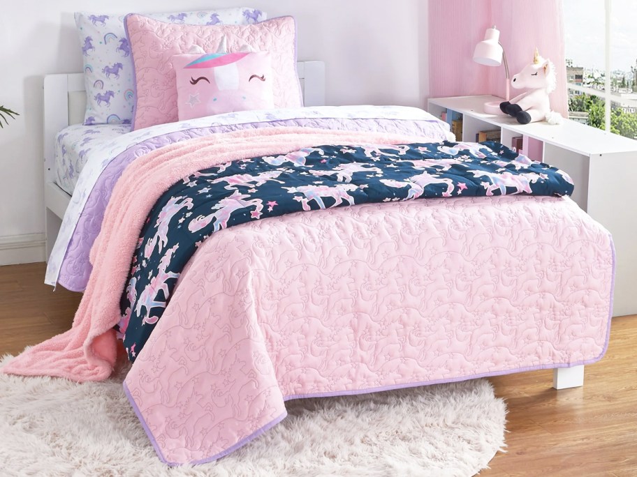 pink unicorn quilt set on bed