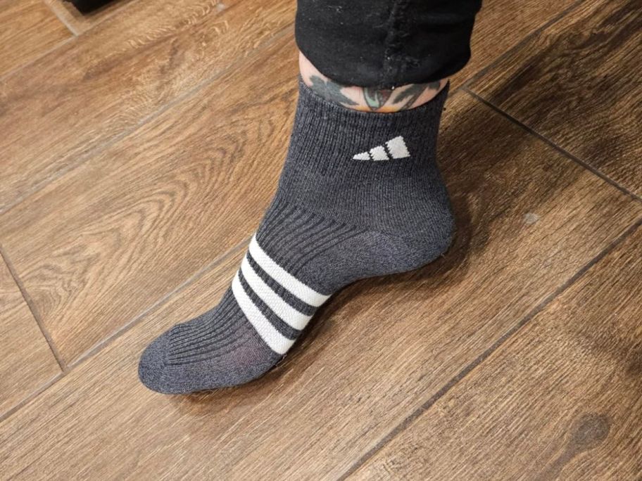 woman wearing grey and white adidas sock